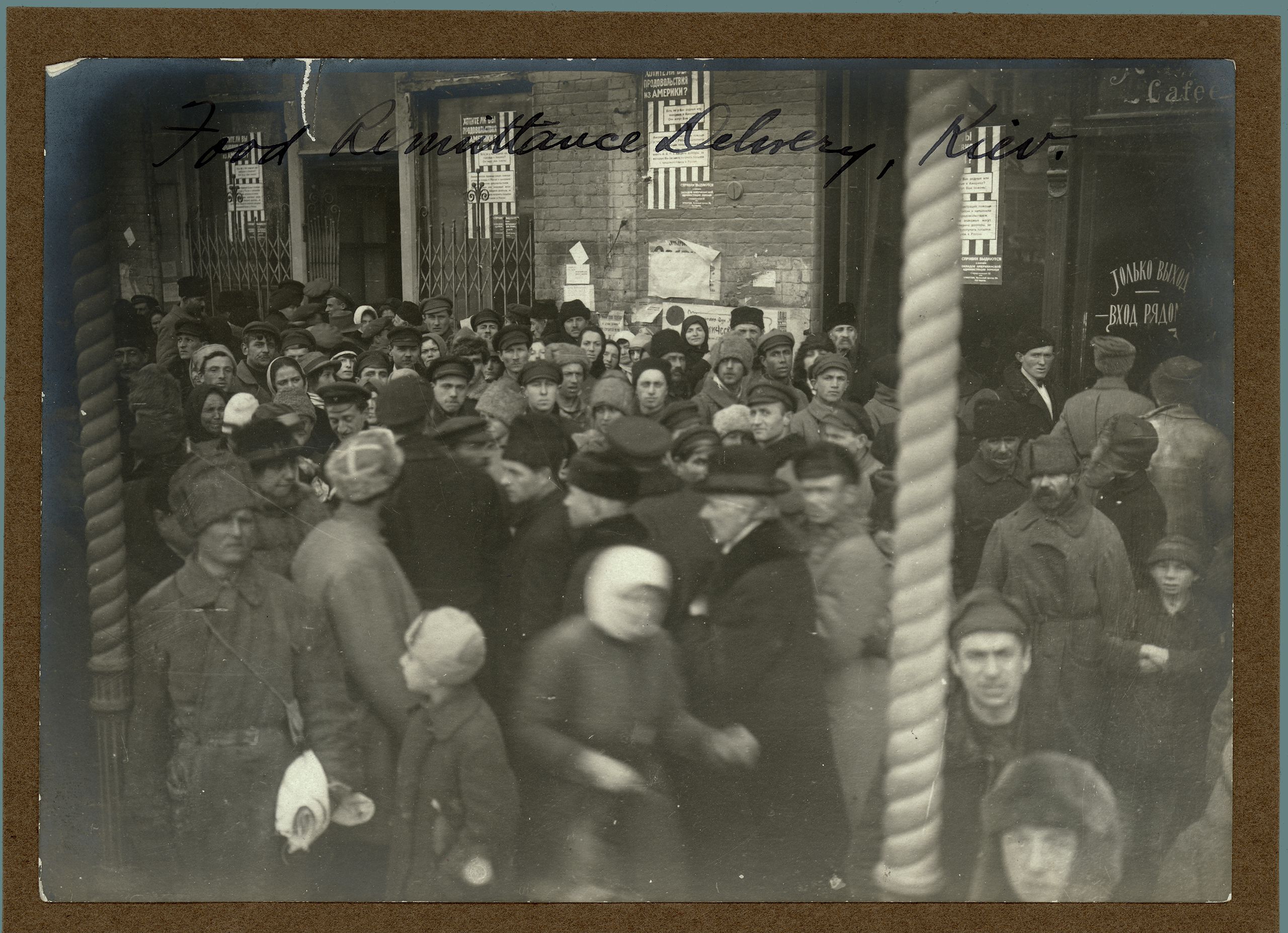 Black and white photograph showing a crowd of people outside waiting for an ARA Food Remittance Delivery, Kiev, circa 1922.