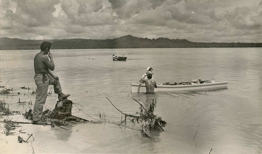 Dynamite conveyed by dory for blasting solid rock coral, 1944.