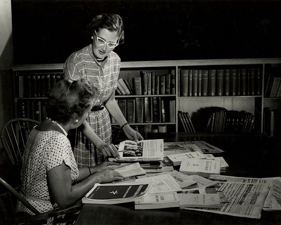 Black and white photograph of Mrs. Peterson and Mrs. Godsall discussing the Hoover Library's current acquisitions concerning North Africa, 1950s. From the Hoover Institution on War, Revolution and Peace Records, at the Hoover Institution Archives