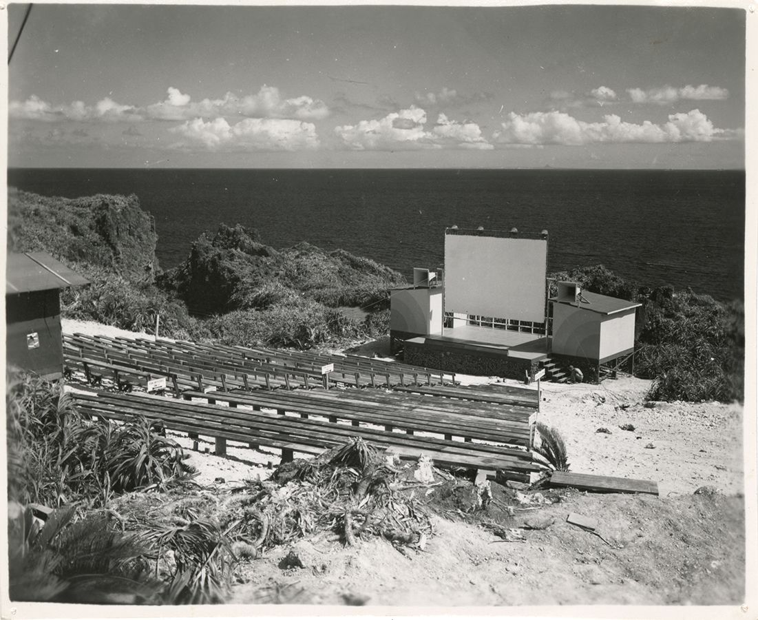 Black and white photograph of a stage and empty bleachers where USO shows would perform for the troops on Okinawa, 1945.