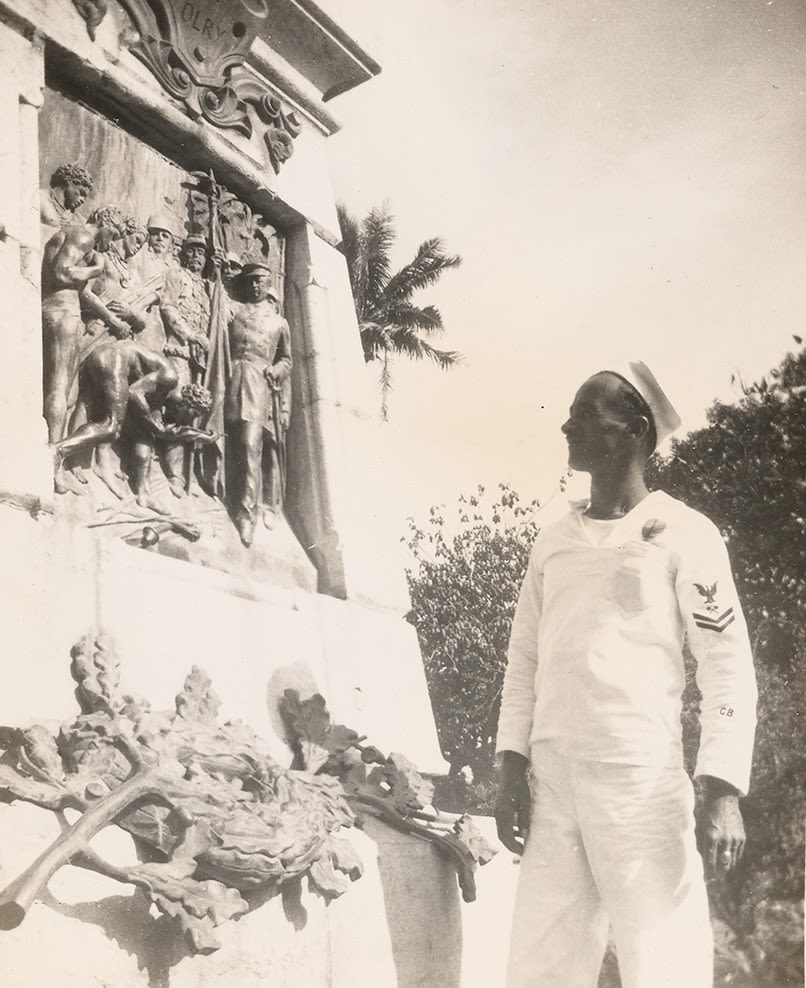 Black and white photograph of Seabee Al Perron looking at a monument in Noumea, New Caledonia, December 1944.