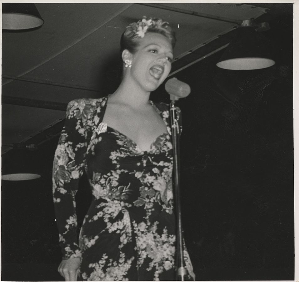 Black and white photograph of Martha O'Driscoll singing at a USO show in New Caledonia, 1945.