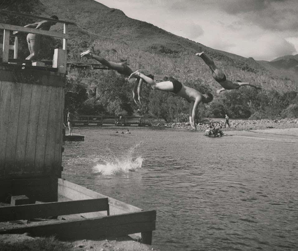 Black and white photograph of men diving into the water at a swimming hole on New Caledonia, 1945.