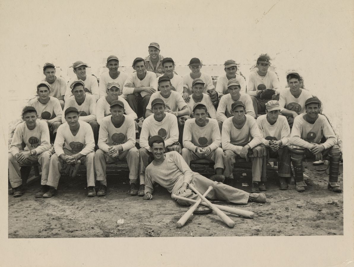 Black and white photograph of the 78th Baseball Club members sitting on bleachers, New Caledonia, 1945.