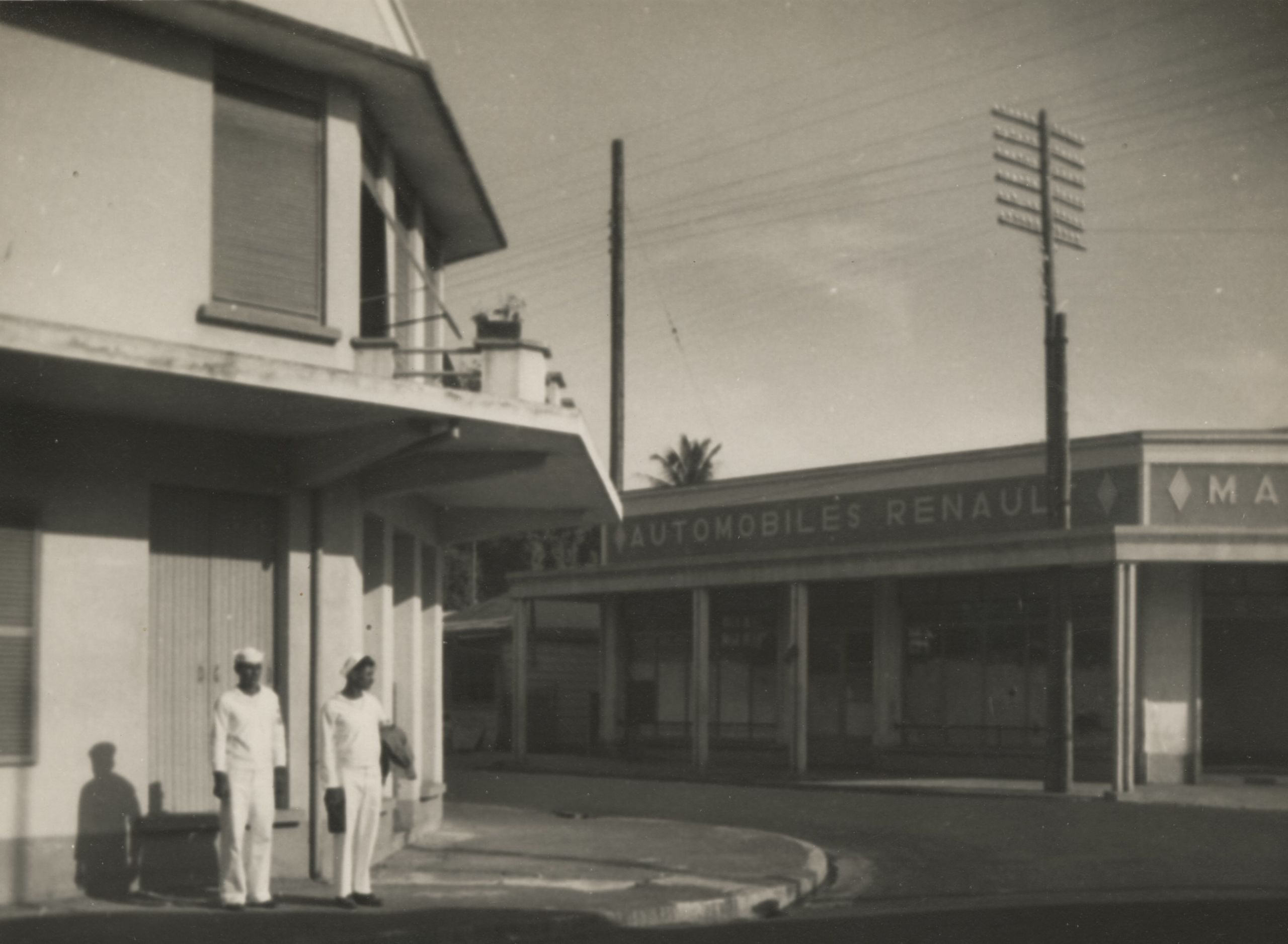 Black and white photograph of two Seabees exploring a city street on New Caledonia, 1944.