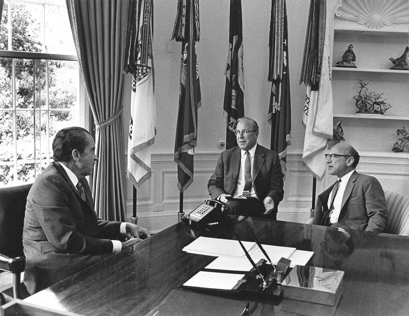 Black and white photograph of President Richard Nixon in the Oval Office with economists George Shultz and Milton Friedman. June 1971. From the Milton Friedman papers, Hoover Institution Archives
