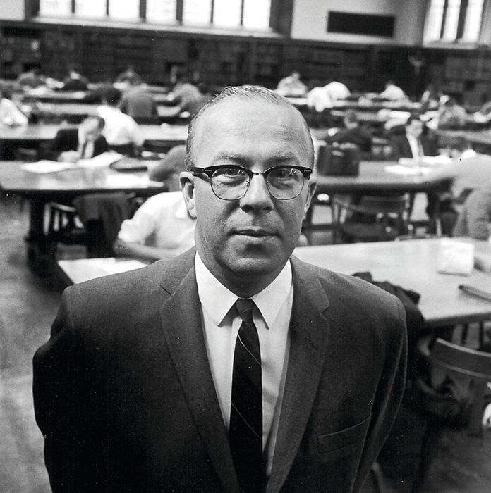 Detail of a black and white photograph of George Shultz, dean of the Graduate School of Business, at the University of Chicago library, circa 1962. George Pratt Shultz Papers, Hoover Institution Library & Archives