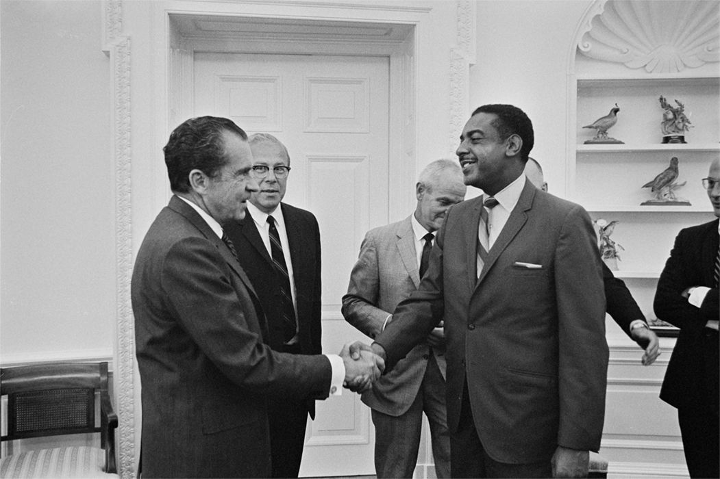 Black and white photograph of President Nixon greets a Georgia State Advisory Committee member in the Oval office, August 6, 1970.
